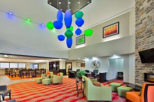 a lobby with a waiting area with chairs and tables at Holiday Inn Express Harrisburg NE, an IHG Hotel in Manadahill