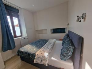 una piccola camera da letto con un letto e una finestra di Appartement 2 chambres près de Genève a Contamine-sur-Arve