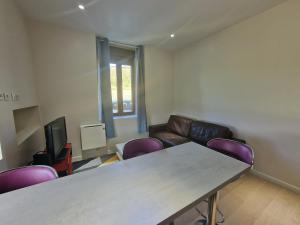 una stanza con un tavolo, sedie e un divano di Appartement 2 chambres près de Genève a Contamine-sur-Arve