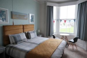 Un dormitorio con una cama grande y una ventana en Ainsley Court Guest House, en Scarborough