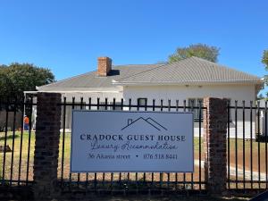 a sign on a gate in front of a house at Cradock Guest House in Cradock