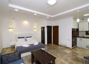 ein Schlafzimmer mit einem Bett und einem Tisch sowie eine Küche in der Unterkunft Apartaments on Komitas 20 in Yerevan