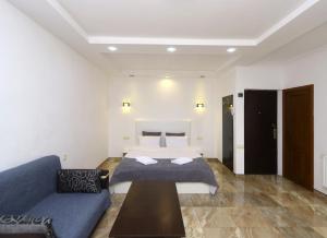 a bedroom with a bed and a blue couch at Apartaments on Komitas 20 in Yerevan