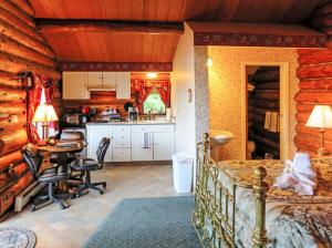 a kitchen and a bedroom in a log cabin at A Cabin on the Cliff in Seward
