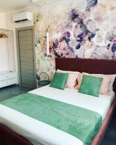 ein Schlafzimmer mit einem großen Bett mit grünen und rosa Kissen in der Unterkunft BBLoveBologna in Castenaso