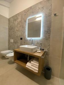 ein Badezimmer mit einem Waschbecken, einem WC und einem Spiegel in der Unterkunft BBLoveBologna in Castenaso