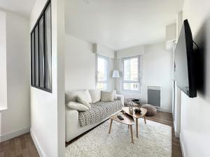uma sala de estar branca com um sofá e uma mesa em Appartement de charme hypercentre em Brest