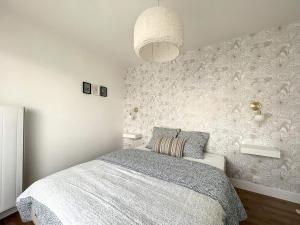 1 dormitorio con 1 cama y una pared con flores en Appartement de charme hypercentre, en Brest