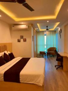 a bedroom with a bed and a desk and a table at The Grand Anukampa Inn Pink City in Jaipur