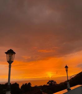 two street lights with a sunset in the background at Hotel Villa Degli Aranci in Maratea