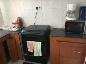 a kitchen with a black stove and a microwave at Pacho Homestay in Kisumu