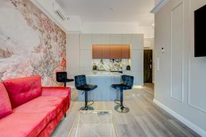 a living room with a red couch and a table at Allure NOVA Aparthotel in Szczecin