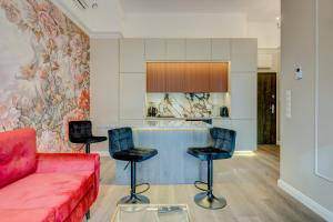 Allure NOVA Aparthotel في شتتين: غرفة معيشة مع أريكة حمراء ومطبخ