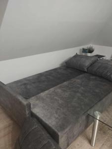 uma cama grande num quarto branco com um sofá em Apartment/mieszkanie u Janusza em Grybów