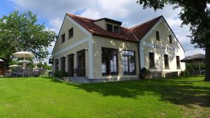 une maison avec une pelouse verte devant elle dans l'établissement Penzion Fousek, à Zvíkovské Podhradí