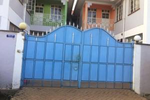 una puerta azul frente a un edificio en Pacho Studio-2, en Kisumu