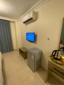 a room with a tv on the wall and a room at Mariam Boutique Hotel in Aqaba