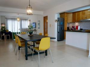 a kitchen and dining room with a table and yellow chairs at Lovely condo at Blue Sea Tower near Juan Dolio beach in Juan Pedro