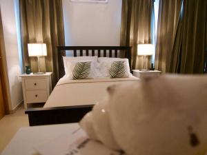 a bedroom with a bed with two lamps on tables at Lovely condo at Blue Sea Tower near Juan Dolio beach in Juan Pedro +19 photos