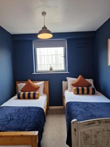 two beds in a room with blue walls at City Centre Snow Hill Apartment (Sleeps 6) in Birmingham