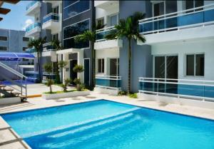 a swimming pool in front of a building at Lovely condo at Blue Sea Tower near Juan Dolio beach in Juan Pedro