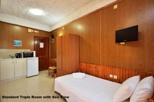 1 dormitorio con 1 cama y TV en la pared en Katerina Rooms for Rent, en La Canea