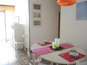 een eetkamer met een witte tafel en stoelen bij Comfy&cozy flat next to the beach - Beahost in Bibione