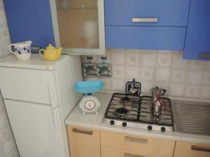 een keuken met een kookplaat en blauwe kasten bij Comfy&cozy flat next to the beach - Beahost in Bibione