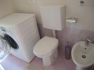 een badkamer met een wit toilet en een wastafel bij Comfy&cozy flat next to the beach - Beahost in Bibione