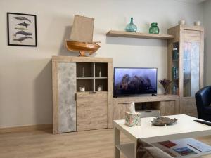 uma sala de estar com televisão e um centro de entretenimento em madeira em HyP - Casa Chalo em Sotomayor