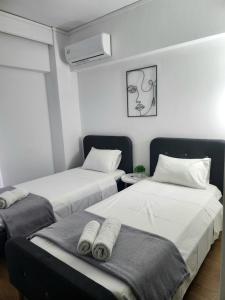 a room with two beds with towels on them at Harmony Elegant Central Apartment in Rhodes Town