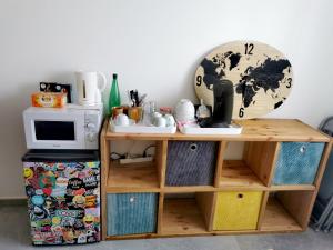 einen Schreibtisch mit einer Mikrowelle und einer Uhr an der Wand in der Unterkunft Chambre d'hôte in Grabels + 2 Fotos