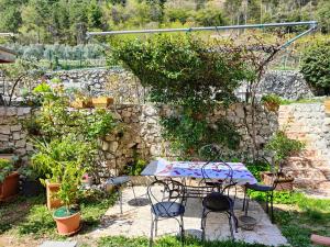 een tafel en stoelen in een tuin met een stenen muur bij Casa Granada 