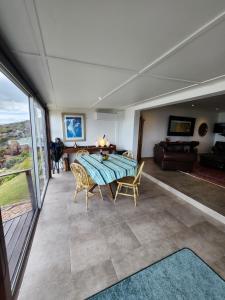 a dining room with a table and chairs and a couch at Rocky Bay on the View in Gordonʼs Bay