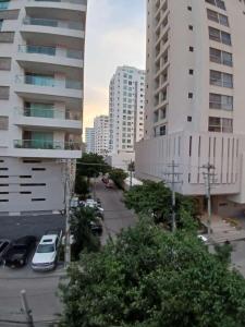 a city street with cars parked in a parking lot at Hotel Bahia Plaza in Santa Marta