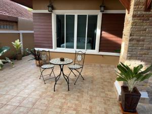 een patio met 3 stoelen en een tafel op een patio bij Kathu Home with Mountain View in Kathu