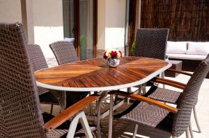 a wooden table with chairs and a vase of flowers at Vila Alma in Baile Felix