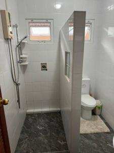 a white bathroom with a toilet and a window at Kathu Home with Mountain View in Kathu