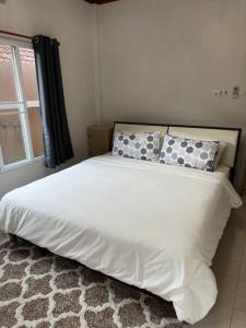 una camera da letto con un letto bianco con cuscini e una finestra di Kathu Home with Mountain View a Kathu