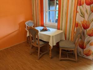 a dining room with a table and chairs and a window at Ulmenzweig Apartment in Siegsdorf