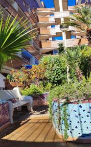 un banc et des plantes devant un bâtiment dans l'établissement Costa de Marfil I-SERVHOUSE, Castellón de la Plana