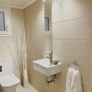 ロードス・タウンにあるHarmony Elegant Central Apartmentのバスルーム(白い洗面台、トイレ付)