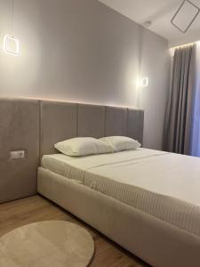 een slaapkamer met een groot bed met een kussen erop bij TOP-Apartments in Pristina