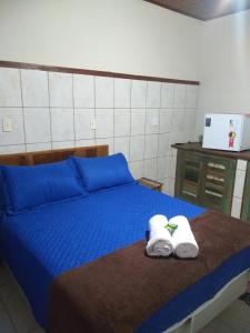 蒂拉登蒂斯的住宿－Suítes Doce Jasmim，一间卧室配有蓝色的床和毛巾