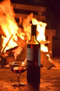 a bottle of wine and a glass in front of a fire at Hospedaje Dulce Piedad in Ambato