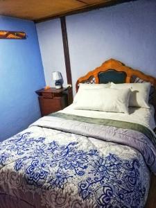 1 dormitorio con 1 cama grande y cabecero de madera en Hospedaje Dulce Piedad en Ambato
