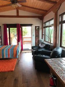 a living room with a couch and a bed and windows at Casita Luna in Santa Fe