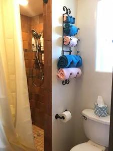 y baño con ducha, aseo y toallas. en Casita Luna, en Santa Fe