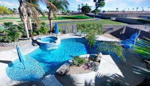 een zwembad in het midden van een tuin met palmbomen bij Desert Retreat Oasis in La Quinta