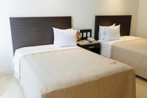a hotel room with two beds and a telephone at Diverxo Hotel & Villas in Tuxtla Gutiérrez